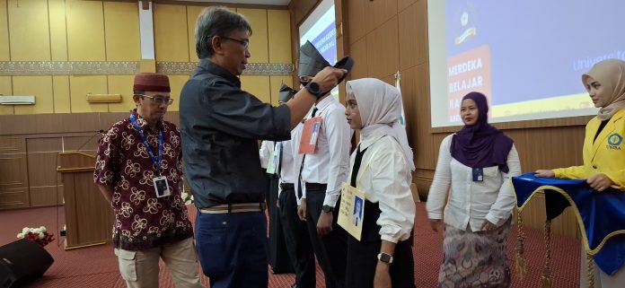 Rektor Universitas Batam, Prof. Dr. Ir. Samsul Rizal, M.Eng, IPU, ASEAN, Eng menyerahkan alat-alat PKKMB secara simbolis kepada beberapa mahasiswa baru, Rabu (25/9/2024), (uly)