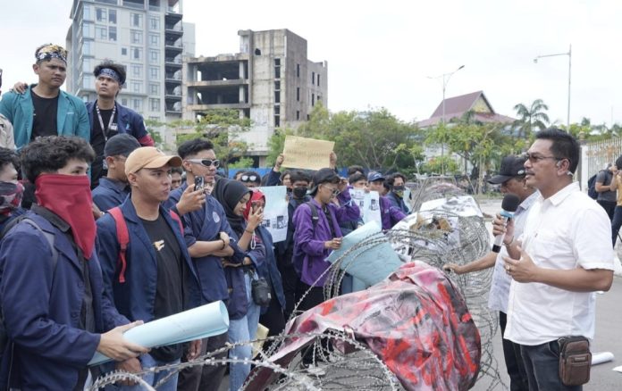 Direktur Pelayanan Terpadu Satu Pintu, Harlas Buana menemui puluhan mahasiswa yang menggelar aksi unjuk rasa di gerbang masuk BP Batam, Senin (23/12/2024). (Humas BP Batam)