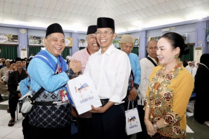 Wali Kota Batam, Amsakar Achmad, bersama Wakil Wali Kota Batam, Li Claudia Chandra, menyerahkan bingkisan kepada Jemaah Calon Haji (JCH) Kota Batam di Asrama Haji Batamcentre, Selasa (21/4/2026). (Diskominfo Kota Batam)