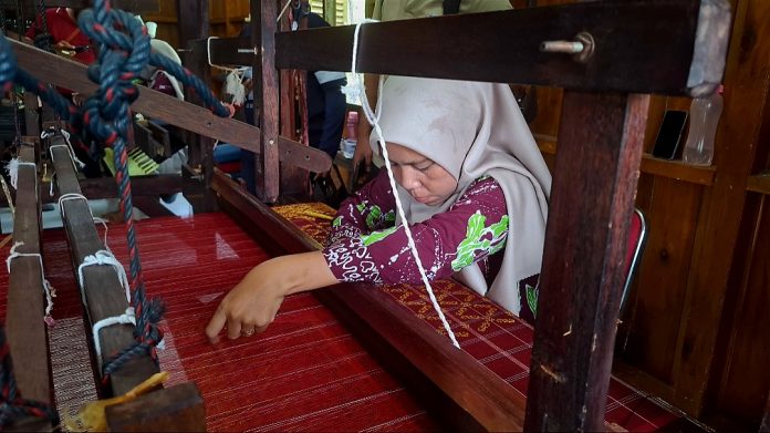 Seorang Pengrajin di Rumah Tenun Lingga sedang menunjukkan cara menenun selembar kain beberapa waktu lalu. (uly)