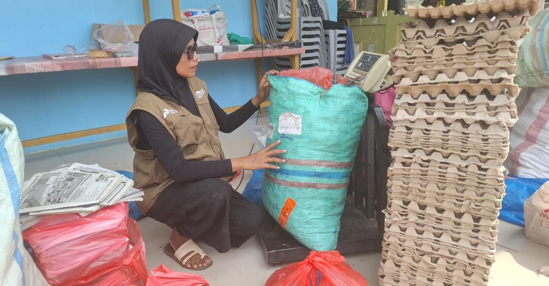 Nella sedang menimbang sampah menggunakan timbangan barang yang berasal dari bantuan CSR Pertamina. (uly)