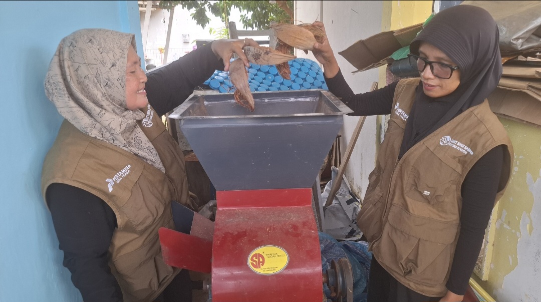 Nella dan Kartini sedang memasukkan sabut kelapa ke dalam mesin pencacah bantuan dari CSR Pertamina. (uly)